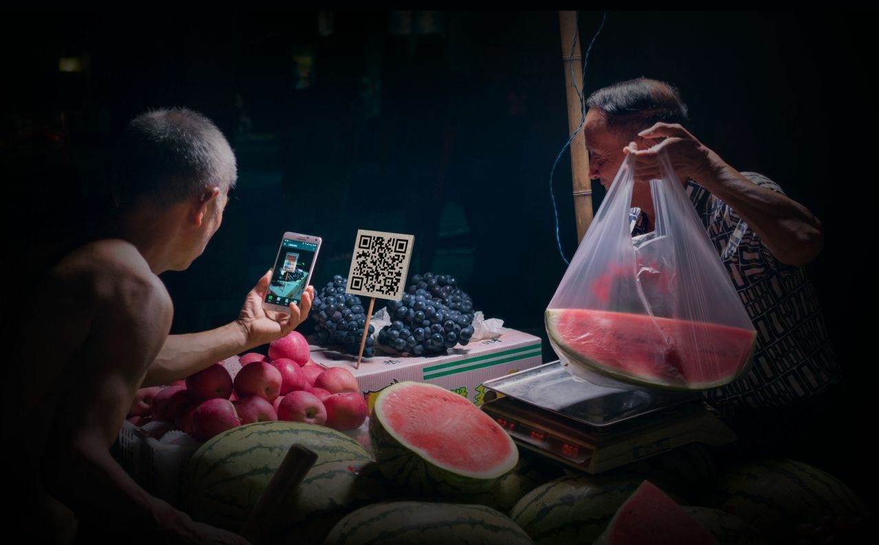农产品市场摊贩接受微信支付（图片来源：中国摄影家协会 蒋廷举)